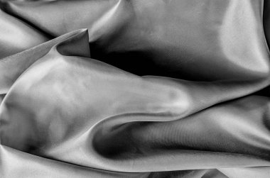 Zarif kıvrımları ve pürüzsüz, parlak yüzey dokusu olan lüks siyah ipek kumaşı kapat