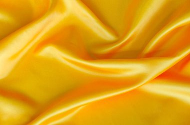 Cilalanmış sarı ipek kumaş, ipek gibi parıltılı ve güzel doğal kumaşlı. Tasarım ve duvar kağıdı arkaplanı için uygun.