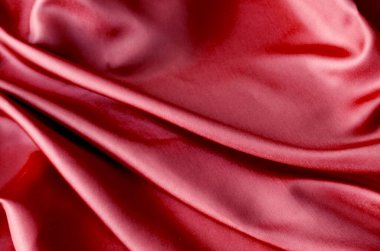 Yumuşak, pürüzsüz dalgalarla kaplanmış parlak, koyu kırmızı kumaş. Tasarım ve duvar kağıdı arkaplanı için uygun.