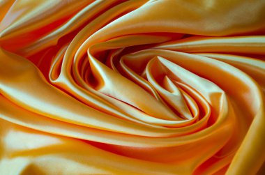 Cilalanmış altın ipekten kumaş, ipek parıltı ve güzel doğal örtüler. Tasarım ve duvar kağıdı arkaplanı için uygun.