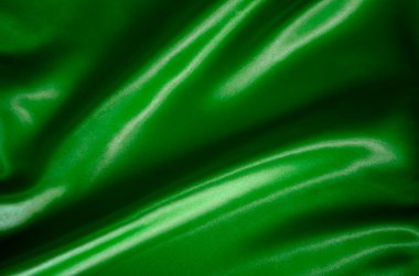 Tasarım ve duvar kağıdı arkaplanı için uygun ipek parıltılı koyu yeşil ipek kumaş üst görünümü.
