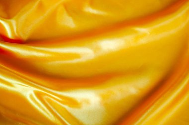 Tasarım ve duvar kağıdı arkaplanı için uygun ipek parıltılı sarı ipek kumaş üst görünümü.