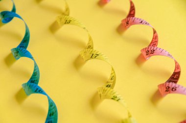 Kıvrık mavi, sarı ve kırmızı şeritli canlı sarı yüzey doğruluğu ve yaratıcılığı temsil ediyor..