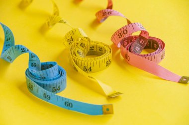 Hassasiyet ve yaratıcılık sarı tuval üzerindeki mavi, sarı ve pembe şeritle sembolize edilir. Diyet kavramı.