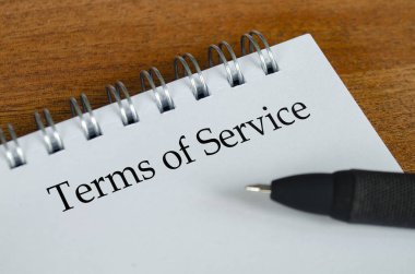 Ahşap masa arkaplanlı beyaz not defterine servis terimleri. Hizmet Koşulları
