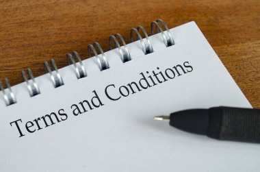 Ahşap masa arkaplanlı beyaz not defterine koşullar ve koşullar metni. Koşullar ve Koşullar ve İş Konsepti