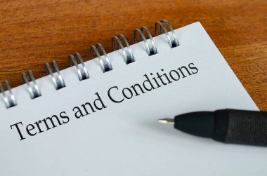 Ahşap masa arkaplanlı beyaz not defterine koşullar ve koşullar metni. Koşullar ve Koşullar ve İş Konsepti