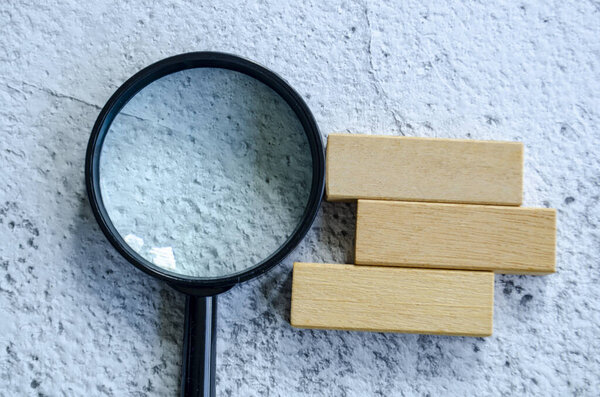 Magnifying glass with customizable space on wooden block for text.