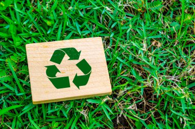 Tahta bloktaki geri dönüşüm sembolünün üst görünümü ve metin için özelleştirilebilir alan. Daha yeşil bir yarın konsepti için.