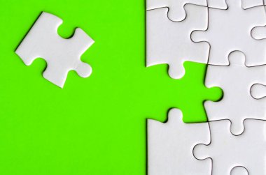 Kayıp beyaz yapbozu birleştirmek yeşil arka plandaki ortaklığı ve birliği sembolize eder.