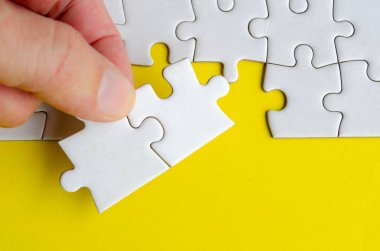 Parlak sarı bir arkaplanda yapboz parçaları tutarken metin veya fikirler için yapboz üzerinde özelleştirilebilir boşluk.