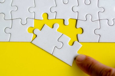 Kayıp yapbozları elle yerleştiriyorum. Çözümlerin birliğini ve maksatlı bağlantısını temsil eden basit ama güçlü bulmaca parçaları kavramı.