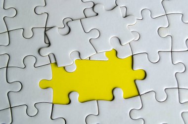 Kayıp beyaz yapbozların üst görünümü, sarı arkaplanda ortaklığı ve birliği simgeliyor..