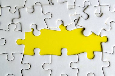 Bağlı yapboz parçalarından canlı sarı bir arkaplanda ortaklık ve birlik sembolü.