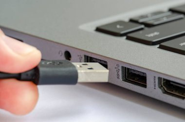 USB, yetkisiz veri transferi veya kötü amaçlı yazılım riskini vurgulayan dizüstü bilgisayara bağlanıyor.