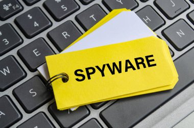 Laptop klavye arkaplanlı beyaz not defterine casus yazılım. Hacker ve dolandırıcılık faaliyet kavramı.