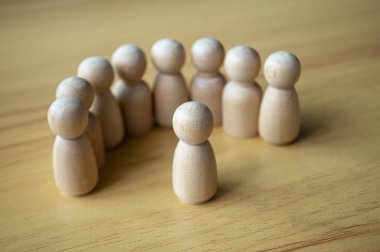 Ahşap yüzeyde bej kazıklara bakan bir figür.