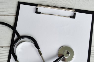 Beyaz arkaplanda steteskop ve metin veya ileti için özelleştirilebilir alanı olan tıbbi pano.