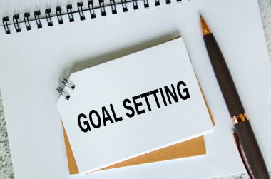 Beyaz not defterindeki hedef ayarlama metninin üst görünümü. İş Hedefi konsepti.