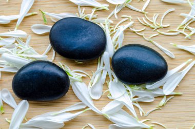 Simetrik düzlemde üç pürüzsüz zen taşı düz ahşap arkaplan ve metin için özelleştirilebilir alan.