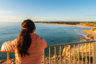 Günbatımında Güney Liman 'dan Port Noarlunga' ya bakan kadın, Güney Avustralya