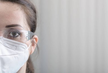 Hemşirenin koruyucu gözlüklü ve N95 maskeli yüzü hastanede.