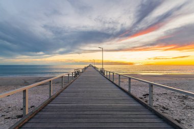 Gün batımında Henley Sahili rıhtımında sakin deniz ve bulutlarla, Güney Avustralya