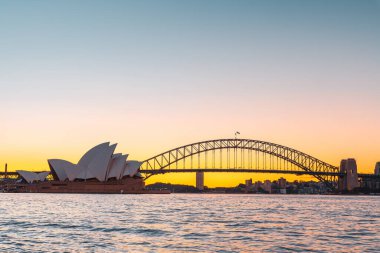 Sydney, Avustralya - 20 Nisan 2022: Günbatımında Royal Botanic Garden 'dan izlenen Opera Binası ile Sydney Limanı Köprüsü