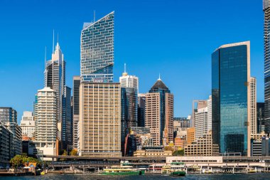 Sydney, Avustralya - 17 Nisan 2022: Güneşli bir günde feribottan Circular Rıhtımı 'na doğru açılan yeni AMP ve Credit Suisse binalarıyla Sydney şehri ufuk çizgisi