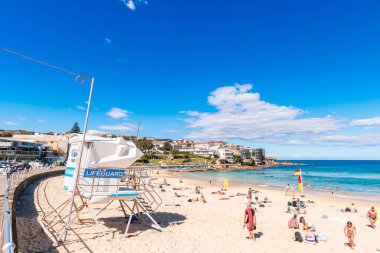 Sydney, Avustralya - 20 Nisan 2022: Bondi Plajı 'nda insanlar bir günde kumda dinleniyor. Bondi Sahili, Avustralya 'da Avustralya plaj kültürü ve yaşam tarzının bir sembolüdür.
