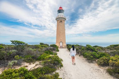 Güney Avustralya, Kanguru Adası 'ndaki Cape Du Couedic Deniz Feneri' ne doğru yürüyen bir kadın.