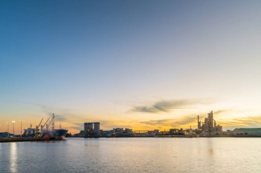 Port Adelaide sanayi limanı. Akşam karanlığında Port Nehri 'ni geçen gemiler görülüyor.