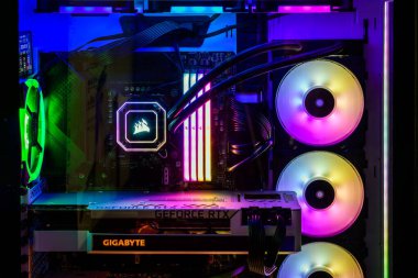 Adelaide, Avustralya - 24 Aralık 2023: RGB parlayan LED ışıklar, CPU su soğutma ve karanlık bir odada çalışırken NVidia GeForce RTX grafik kartı ile modern oyun bilgisayarının yakın görüntüsü