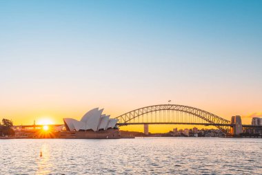 Sydney, Avustralya - 20 Nisan 2022: Harbour Bridge ile Sydney Opera Binası gün batımında Royal Botanic Gardens 'tan izlendi