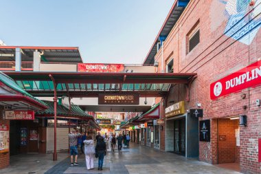 Adelaide, South Australia - December 19, 2020: Cafes, restaurants and boutiques with people in Adelaide City Chinatown centre viwed towards Gouger Street entrance on an afternoon clipart