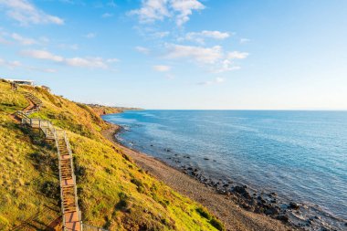 Hallett Koyu 'ndan Marion Yürüyüş Patikası' na. Gün batımında deniz manzaralı, Güney Avustralya.