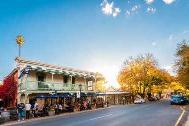 Hahndorf, Adelaide Hills, Güney Avustralya - 1 Mayıs 2021: İnsanlar Hahndorf Inn Alman restoranında akşam yemeği yerken sonbahar akşamı ana caddeden izleniyor