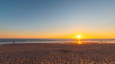 Port Noarlunga plajı, günbatımında insanlarla, Güney Avustralya