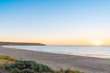 Günbatımında Maslin Sahili, Güney Avustralya 'daki Fleurieu Yarımadası' ndaki Red Ochre Koyu 'na doğru görüldü. 1975 'te plajın güney yarısı Avustralya' nın ilk resmi çıplak plajı ilan edildi..