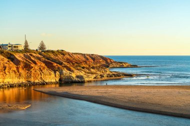 Günbatımında Güney Port Beach, Güney Avustralya 'da insanların yürüdüğü Onkaparinga Nehri ağzı