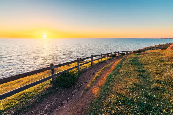 Günbatımında okyanus manzaralı Hallett Koyu Koruma Parkı Sahil Yolu, Güney Avustralya