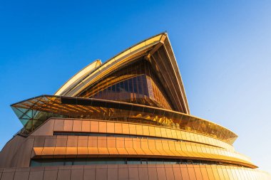 Sydney, Avustralya - 20 Nisan 2022: Günbatımı saatinde Sydney Opera Tiyatrosu 'nun zemin katından izlenen güzel manzarası