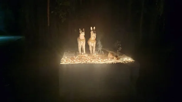 At heykelinin etrafında mum yakmak (Diya). 