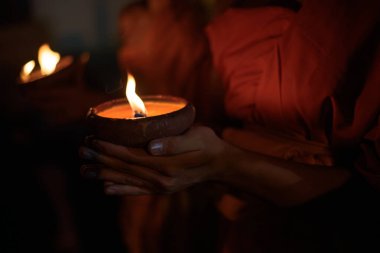 Budist keşiş elleri karanlıkta mum kabını tutuyor, Chiang Mai, Tayland