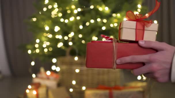 Tegen Achtergrond Van Een Kerstboom Geeft Een Man Een Meisje — Stockvideo