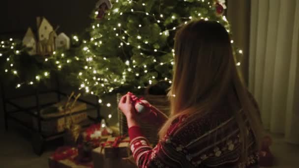 女の子は新年のおもちゃを見て クリスマスツリーに掛けます クリスマスの雰囲気 新年はちょうど角を曲がったところです — ストック動画