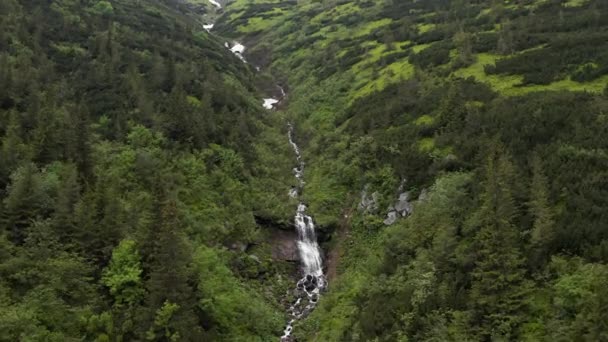 空中拍摄展示了令人叹为观止的高山美景和一条瀑布连绵不绝的山河 摄像机慢慢地向前移动 靠近瀑布 — 图库视频影像
