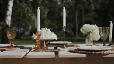 Kamera yavaş bir tempoda inanılmaz dekore edilmiş bir masa, eski sofra takımı, inanılmaz ortancalı vazolar, nefis şarap kadehleri ve alışılmadık şamdanlarla yan yana hareket ediyor..