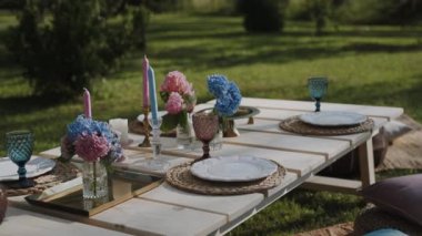 Zarif dekore edilmiş ve özel anlar için hazırlanmış bir masa. Parlak tabaklar ve eşsiz sihirli gözlükler. Kamera tablonun tüm içeriğini ayrıntılı olarak gösterir.