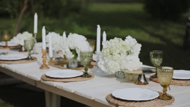 オープンエアガーデンは 絶妙なテーブルウェア ろうそく カラフルな花で飾られた見事に配置されたテーブルをホストし お祝いや特別なイベントに最適です — ストック動画